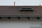 Low angle view of the roof of a building with a dormer on it at daytime