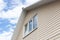 A low angle view of roof upper floors of a house in daytime against blue sky.