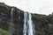 low angle view of Seljalandsfoss waterfall in highlands under cloudy sky