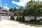 Low angle view of the side of a large gray craftsman new construction house with a landscaped yard a three car garage