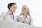 Low angle view of smiling businesswomen using digital tablet while standing on terrace against sky