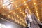 Low angle view of smiling young businesswoman in suit standing against illuminated roof