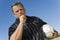 Low angle view of soccer referee showing yellow card against blue sky