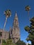 Low angle view of the steeple of Church of San Juan Bautista in the old center of town Arucas, Gran Canaria, Spain with palms.