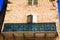 Low angle view on stone facade of typical French house and balcony with ancient ornate lattice work - Castellane, France