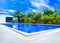 Low angle view of swimming pool in modern resort with blue sky background