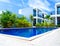 Low angle view of swimming pool and resort with blue sky background, resort hotel landscaping concept.