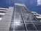 Low angle view of a tall office building on a bright, sunny day with wispy clouds