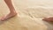 low angle view to barefeet moving on white sand beach with some wave from sea hitting the beach, summer relax vacation holiday
