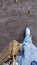 Low angle view to walking lady in gray jean with white shoes and brown shoulder bag