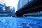 Low angle view of a underside of elevated train track over a blue and freshly frozen Chicago River during frigid morning
