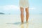 Low angle woman walking barefoot on the beach