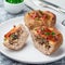 Low carb paleo meat cups, stuffed with champignons, bacon and cheese, garnished with green onion, on  plate, square format