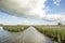 Low clouds above a river in the reedlands in the Nieuwkoop lakes in the Netherlands