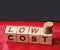 Low cost words on Wooden blocks and coins stack. Sale discount business concept