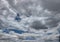 Low dark blue sky and low thunderous white-dark feather clouds