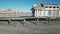 Low drone slide view along a wooden beach pier with a building on it