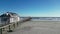 low drone view at the beach going vertically across the wooden Ventnor fishing pier facing the ocean