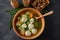 Low fat vegetable soup with chicken meatballs, potato and carrot and fresh herbs in a wooden bowl