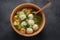 Low fat vegetable soup with chicken meatballs, potato and carrot and fresh herbs in a wooden bowl