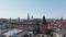 Low flight above roofs of townhouses in urban borough. Tall towers against clear blue sky. Copenhagen, Denmark