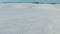 Low flight and takeoff above snow fields in winter, aerial panoramic view. Snow pattern and texture.