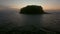 Low flying over fishing boat near wild island with sunset view