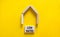 Low house rates symbol. Concept words `Low rates` on wooden blocks near miniature house. Beautiful yellow background, copy space