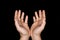 Low key, close up of hands of a faithful mature man praying, hands folded, interlaced fingers in worship to god