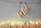 Low key image of christmas image of fabric hearts hanging on rope in front of wooden background. retro filtered with glitter overl