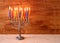 Low key image of jewish holiday Hanukkah background with menorah Burning candles over wooden background.