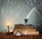 Low key image of white Feather, inkwell, old books and candle and glitter lights background on old wooden table