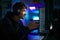 Low Key Lighting Shot Of Male Gamer In Front Of Computer Screens With Headphones And Controller