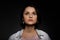 Low key portrait of serious young brunette multiethnic woman in pink tank and white shirt looking up