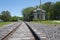 A low level view of a single track railway line on a sunny day, with the Chicago and Alton Railroad Depot building on the right ha