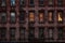 Low light night time view of a red  brick face building in Manhattan, New York City. Lights glow warmly through one set of apartme