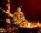 Low light photography of buddha statue with clay lamp on rose petals over the dark blurry background. religion concept