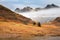 Low lying mist lingering below snowcapped mountain range on Winter afternoon. Langdale Pikes, Lake District, UK.