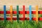 Low multicolored wooden fence on the kindergarten playground.