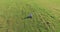 Low orbital flight around man on green grass with notebook pad at yellow rural field.