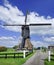 Low sail wip mill in a polder with a blue sky and dramatic shaped clouds, Netherlands