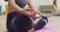 Low section of asian woman practicing yoga sitting in lotus position in yoga class at studio