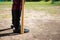 Low section of baseball player holding bat while standing on field