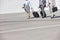 Low section of businesspeople with luggage walking on street