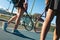 Low section of female multiracial tennis players walking rackets at court on sunny day