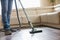 Low section of man cleaning hardwood floor with vacuum cleaner