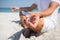 Low section of man practicing meditation at beach