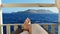 Low section of a man relaxing on the sunbed and enjoying amazing ocean view with rocks on background