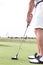 Low section of mid-adult man playing golf against clear sky