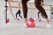 Low section view at row of women stretching feet using fitness ball